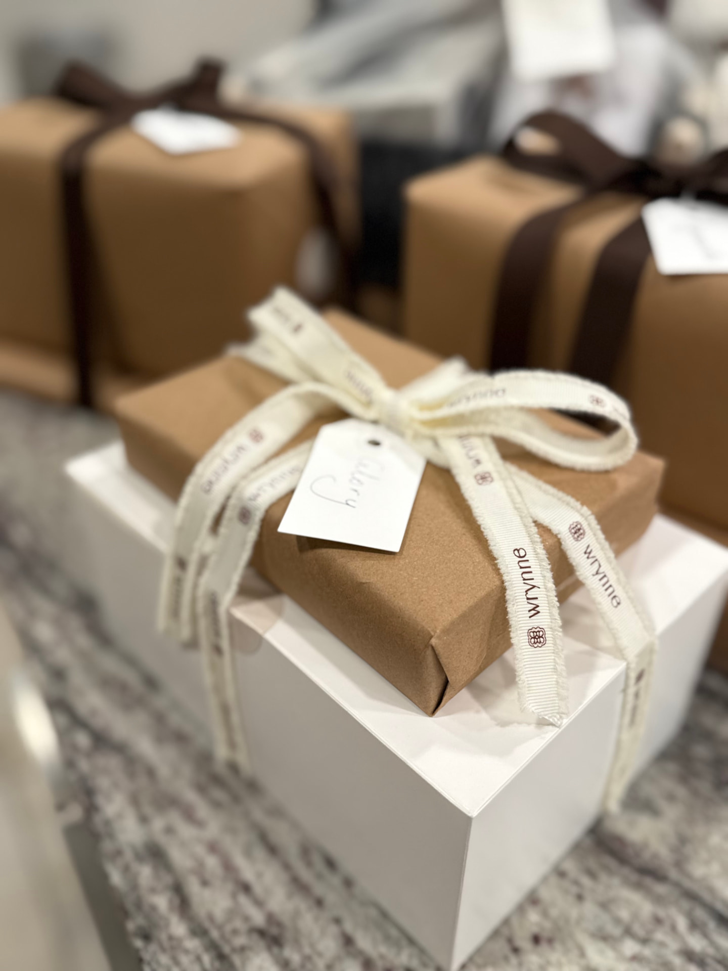 Kraft-wrapped Wrynne holiday gifts with name tags